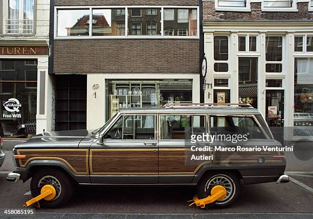 jeep grand wagoneer clamped in amsterdam - parkkralle stock-fotos und bilder