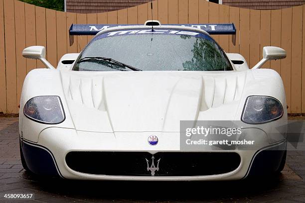 maserati mc-12 parked in front of wooden fence - maserati mc12 stock pictures, royalty-free photos & images