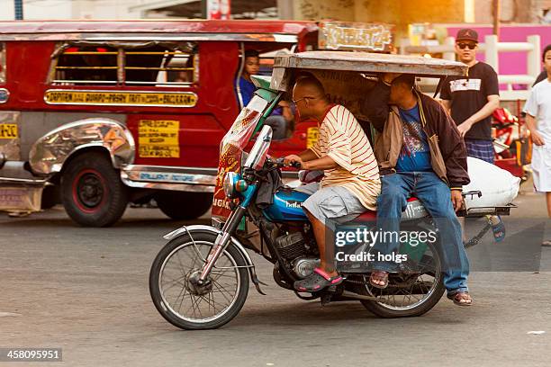 driver and passenger on a motorcycle rickshaw, metro manila - filipino tricycle stock pictures, royalty-free photos & images