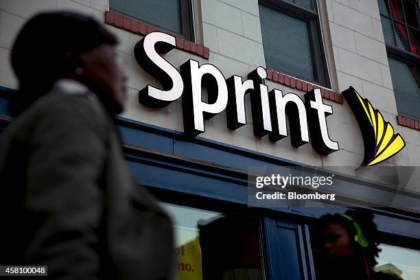 Pedestrians walk past a Sprint Corp. Store in Washington, D.C., U.S., on Friday, Oct. 24, 2014. Sprint Corp. Is expected to release third quarter...