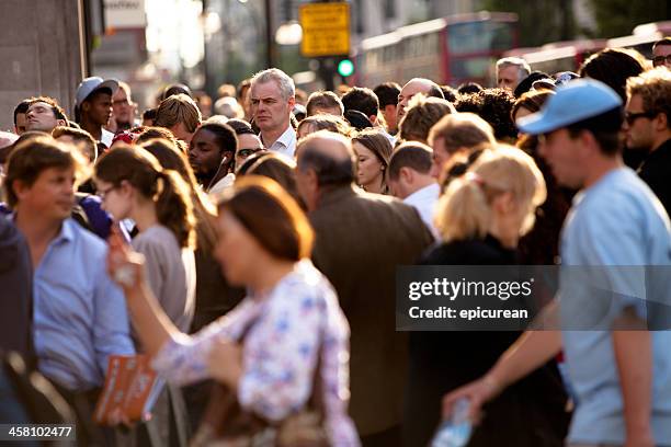 alto homem em um lotado intersecção - standing out from the crowd (expressão inglesa) imagens e fotografias de stock
