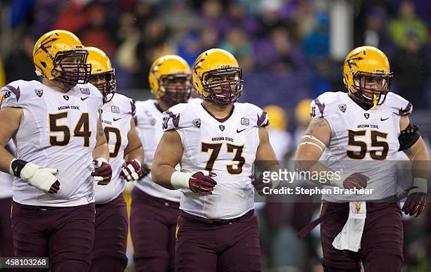 Offensive linemen Tyler Sulka, Vi Teofilo and Christian Westerman of the Arizona State Sun Devils take the field in the first half of play against...
