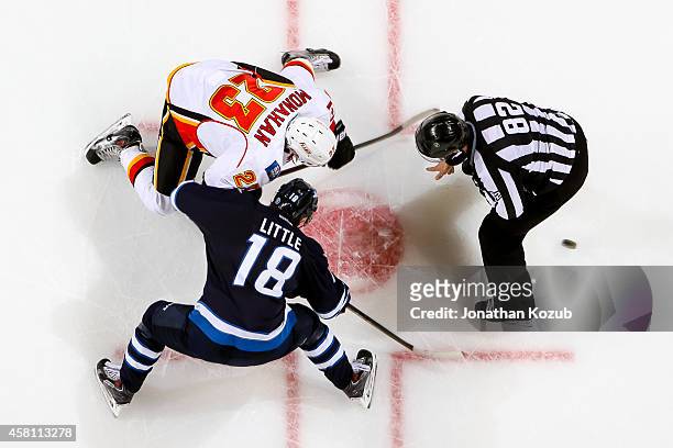 Bryan Little of the Winnipeg Jets takes a second period face-off against Sean Monahan of the Calgary Flames on October 19, 2014 at the MTS Centre in...