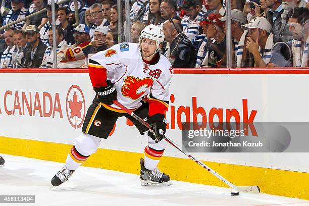 Kris Russell of the Calgary Flames plays the puck along the boards during third period action against the Winnipeg Jets on October 19, 2014 at the...