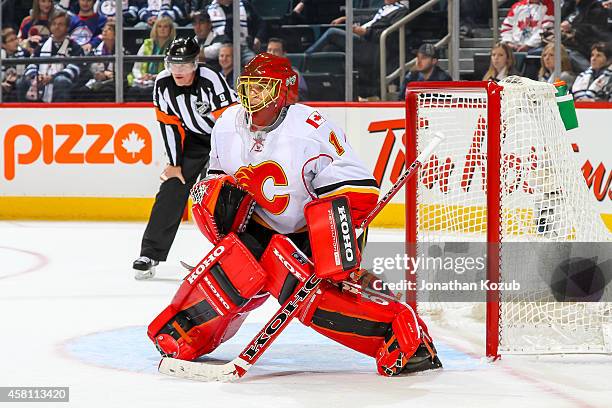 Goaltender Jonas Hiller of the Calgary Flames gets set in the crease during third period action against the Winnipeg Jets on October 19, 2014 at the...
