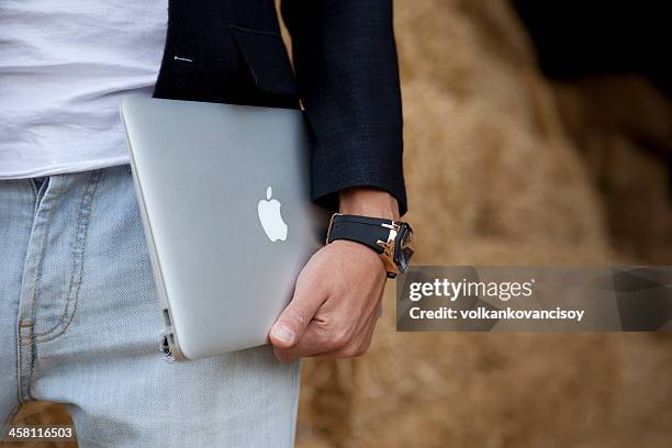 male is holding macbook air - macbook stock pictures, royalty-free photos & images