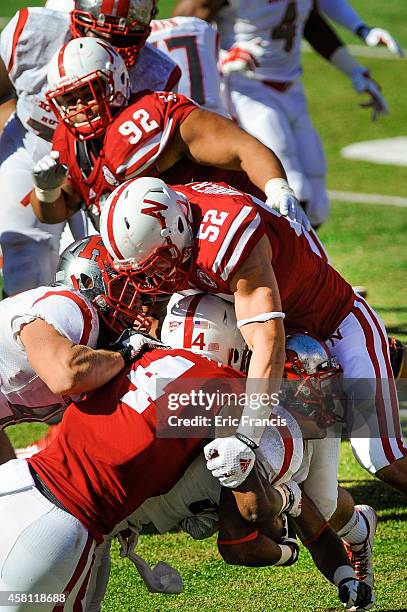 Linebacker Josh Banderas and defensive end Randy Gregory of the Nebraska Cornhuskers wrap up running back Justin Goodwin of the Rutgers Scarlet...