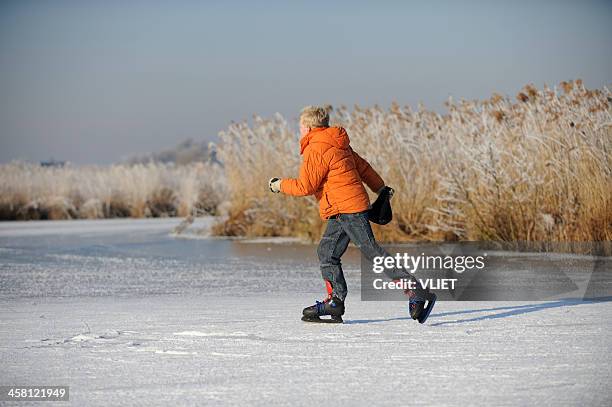 boy ice-skating on a lake in the netherlands - ice skate stock pictures, royalty-free photos & images