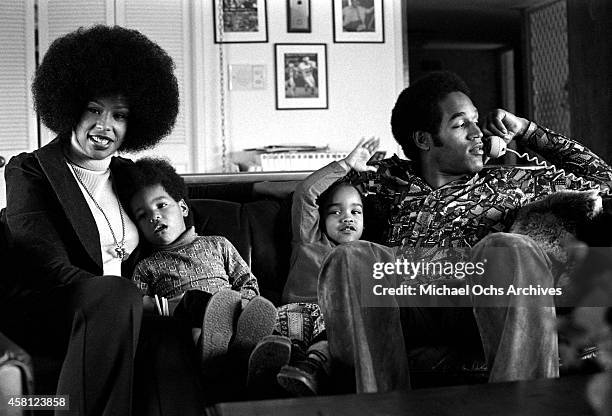 Star O.J. Simspson talks on the phone while doing a portrait session at home with his wife Marguerite Simpson, daughter Arnelle and son Jason on...