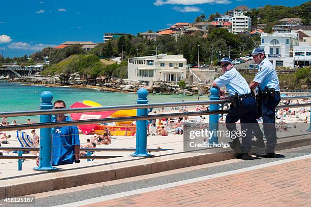 two police officers watch the beach at coogee, sydney - emergency services australia stock pictures, royalty-free photos & images