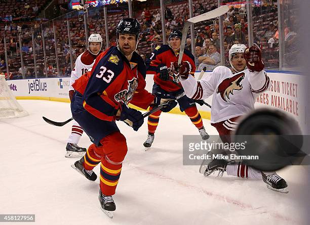 Willie Mitchell of the Florida Panthers and Antoine Vermette of the Arizona Coyotes fight for the puck during a game at BB&T Center on October 30,...