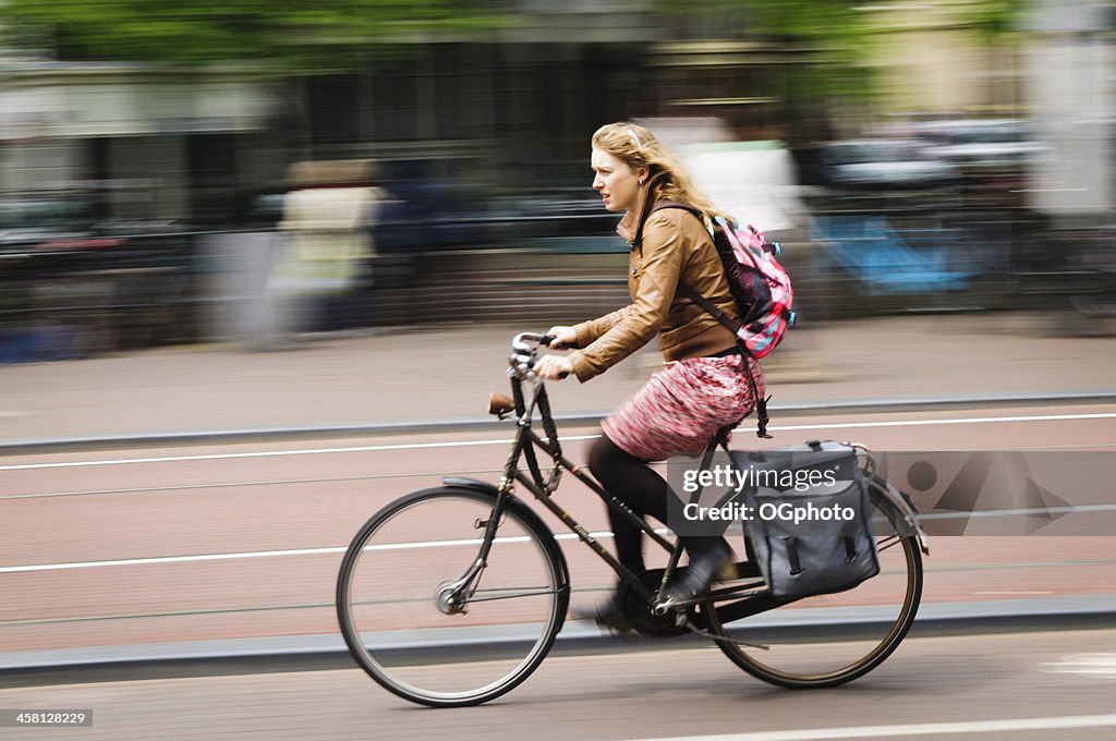Young blonde woman riding a bicycle in Amsterdam, Holland.