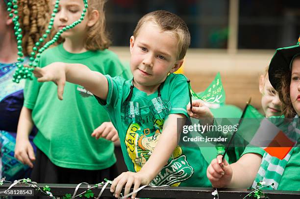 kids throwing beads to st. patrick's day parade goers - saint patricks day parade stock pictures, royalty-free photos & images