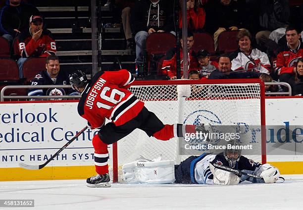 Jacob Josefson of the New Jersey Devils scores the game winning goal during the shootout against Ondrej Pavelec of the Winnipeg Jets at the...