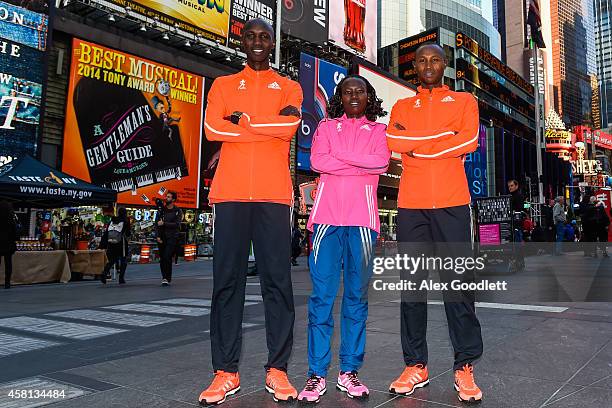 Wilson Kipsang , Mary Keitany and Geoffrey Mutai pose for a picture at Times Square on October 30, 2014 in New York City.