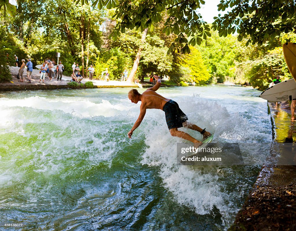 Joven navegar por el río Eisbach en Munich, Alemania