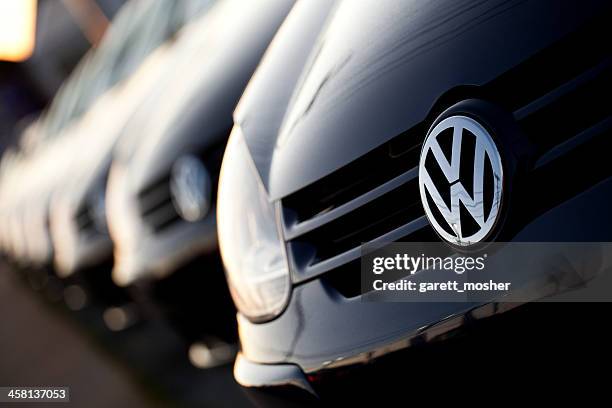 row of new volkswagens at dealership - volkswagen stockfoto's en -beelden