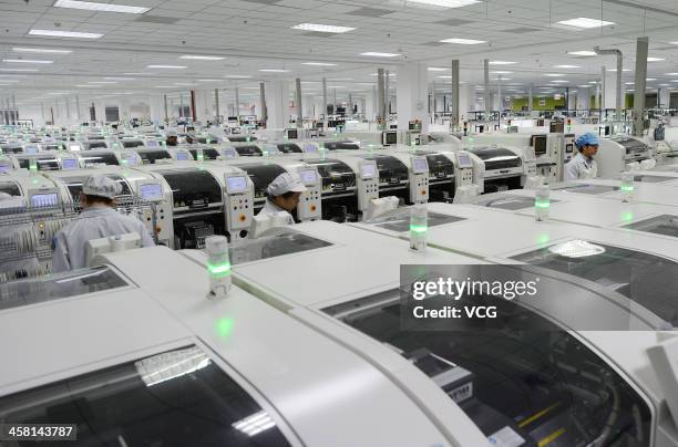 Employees work on the production line of smart phone at the Lenovo MIDH Wuhan Operation Center on December 19, 2013 in Wuhan, China. The plant will...