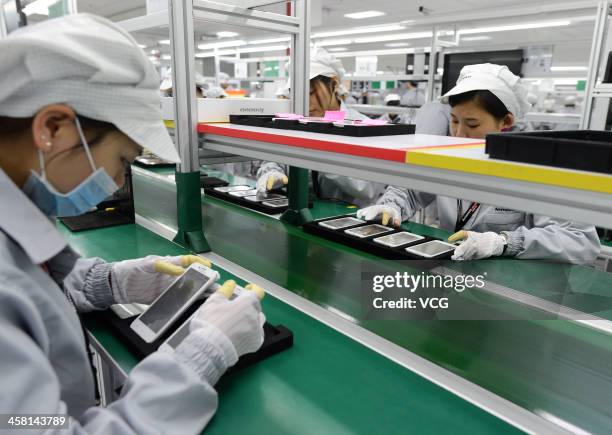 Employees work on the production line of smart phone at the Lenovo MIDH Wuhan Operation Center on December 19, 2013 in Wuhan, China. The plant will...