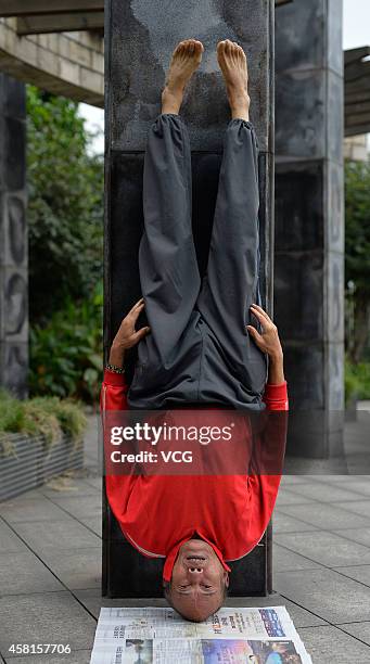 Mr.Zhou, a 73-year-old man from Ba'nan District trains headstand on October 30, 2014 in Chongqing, China. A 73-year-old man trained his head for so...