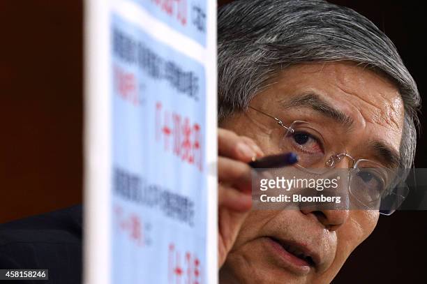 Haruhiko Kuroda, governor of the Bank of Japan , points to a sign as he speaks during a news conference at the central bank's headquarters in Tokyo,...