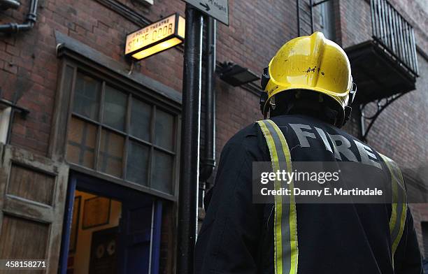 Fireman stands outside the stage door fo the Apollo Theatre following the partial collapse of the theatre's roof last night, on December 20, 2013 in...