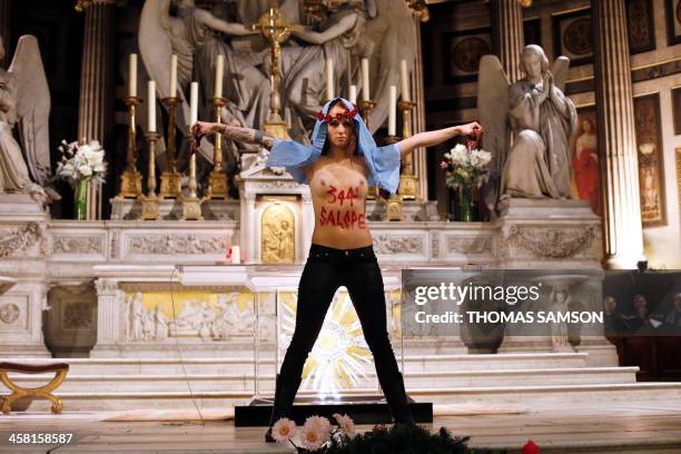 Member of Ukrainian feminist group Femen stands at the altar of the Madeleine church in Paris in a protest against the Catholic Church's stance on...