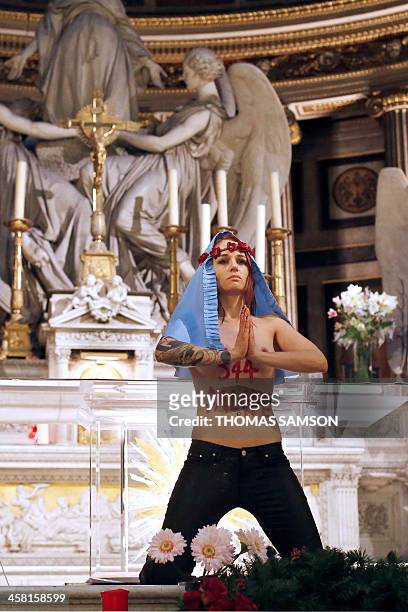 Member of Ukrainian feminist group Femen stands at the altar of the Madeleine church in Paris in a protest against the Catholic Church's stance on...