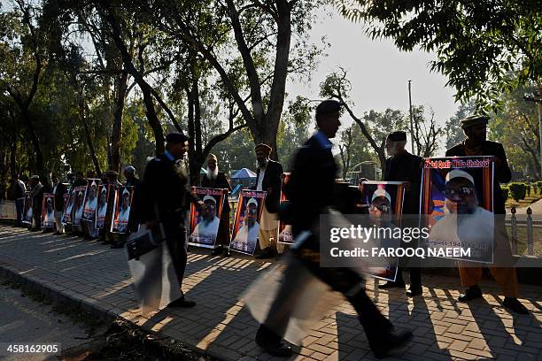 Pakistani policemen walk in front of civil society and Jamaat-e-Islami party activists protesting outside the Bangladeshi embassy in Islamabad on...