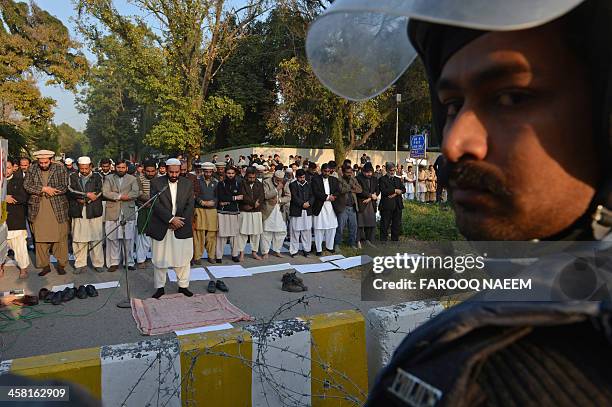 Pakistani civil society and Jamaat-e-Islami party activists pray during a protest outside the Bangladeshi embassy in Islamabad on December 20 against...