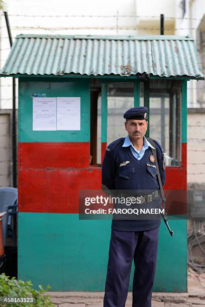 Pakistani policeman stands guard as civil society and Jamaat-e-Islami party activists protest outside the Bangladeshi embassy in Islamabad on...