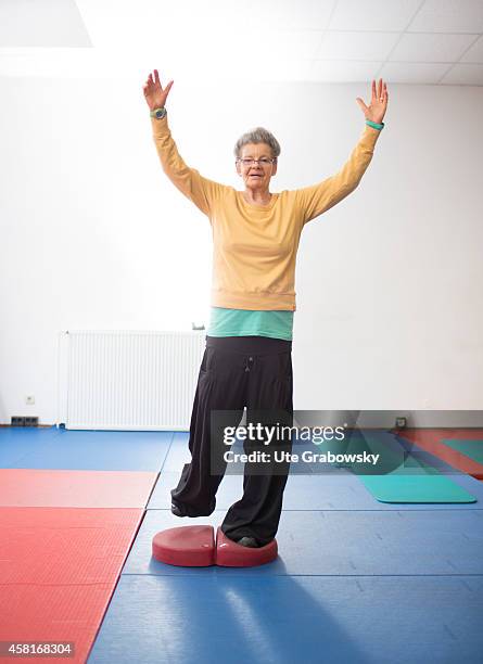 Year-old woman doing balance training in a gym on October 09 in Bonn, Germany. The WHO recommends older adults to stay physically active in order to...