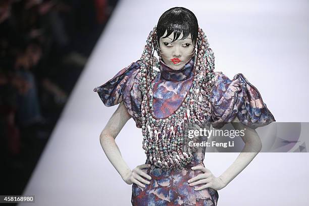 Model showcases designs on the runway at Hu Sheguang Collection show during Mercedes-Benz China Fashion Week Spring/Summer 2015 at Beijing Hotel on...