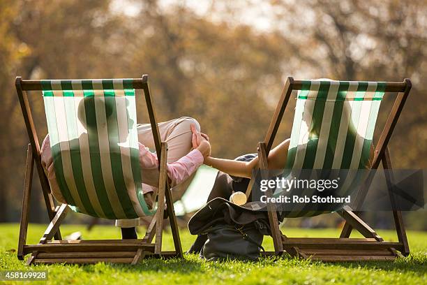 Couple relax in the sunshine in Green Park on October 31, 2014 in London, England. Temperatures in London are forecasted to exceed 20 degrees making...