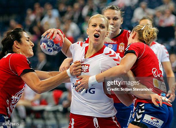 Karolina Siodmiak of Poland is challenged by Sanja Damnjanovic and Jelena Popovic of Serbia during the World Women's Handball Championship 2013 Semi...