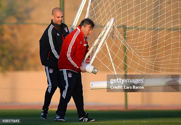 Head coach Josep Guardiola tries to fix a goalpost with his assistant coach during a Bayern Muenchen training session ahaed of the FIFA Club World...