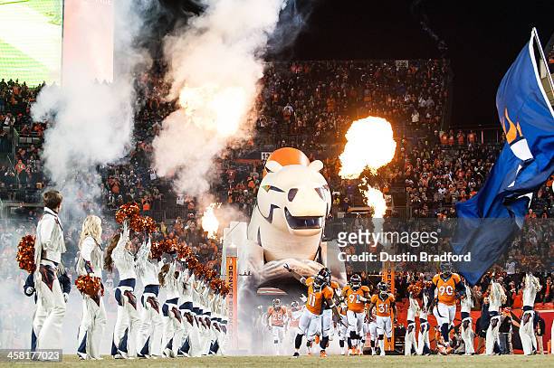 Wide receiver Trindon Holliday of the Denver Broncos leads his teammates onto the field past cheerleaders as pyrotechnics are set off during player...