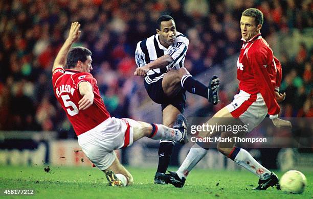 Newcastle striker Les Ferdinand shoots to score the winning goal despite the attempts of the Middlesbrough defenders Nigel Pearson and Steve Vickers...