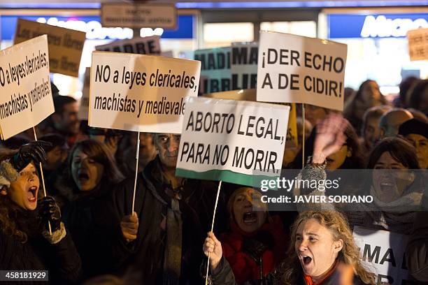 People hold placards meaning "No to clerical, macho and medieval laws" , "Legal abortion, to stop death" and "The right to decide" during a...