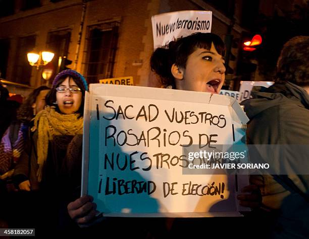 Woman holds a placard reading "Take off your rosaries out of our ovaries! Freedom of choice" during a pro-choice demonstration in Madrid against the...