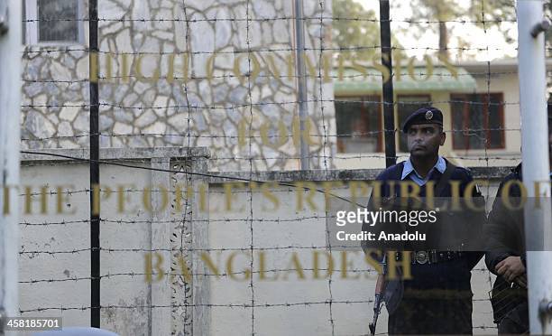 Pakistani policemen stand guard as members of Jamaat-e-Islami Pakistan stage a protest outside the Bangladesh high commission to condemn the...