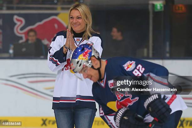 Maria Hoefl-Riesch opens the first bully next to Alexander Barta of Muenchen for the DEL Ice Hockey match between EHC Red Bull Muenchen and Krefeld...
