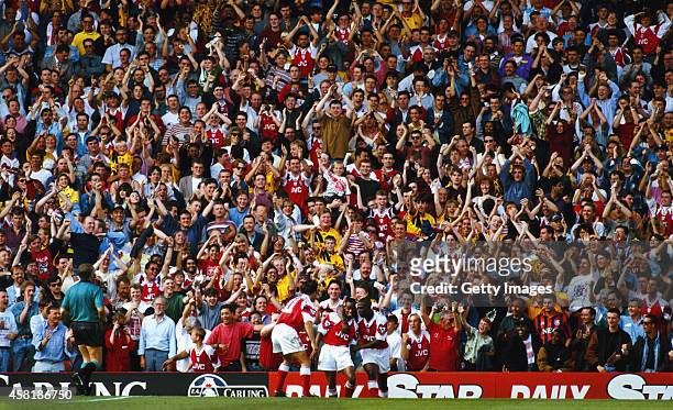 Arsenal Fans in the North Bank celebrate the second of Ian Wright two goals as a lone Everton fan looks on during the FA Premier League match between...