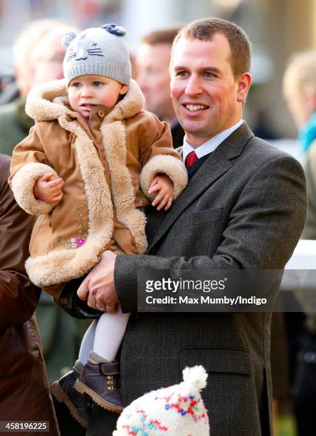Peter Phillips carries daughter Isla Phillips as they attend the Christmas Meeting at Ascot Racecourse on December 20, 2013 in Ascot, England.