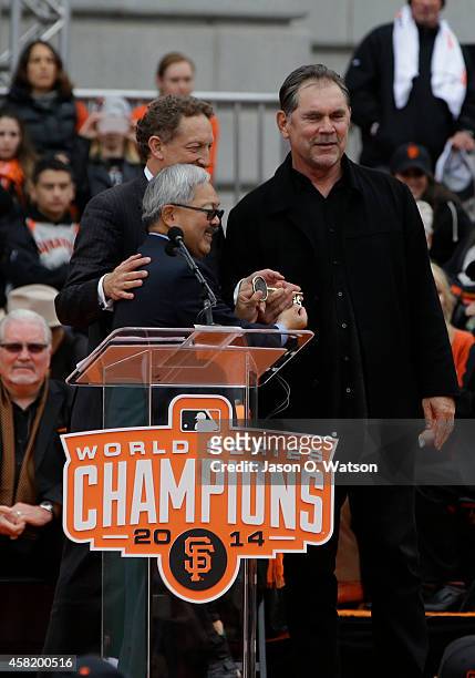 San Francisco Mayor Ed Lee hands a key to the city to owner Larry Baer and manager Bruce Bochy during the San Francisco Giants World Series victory...