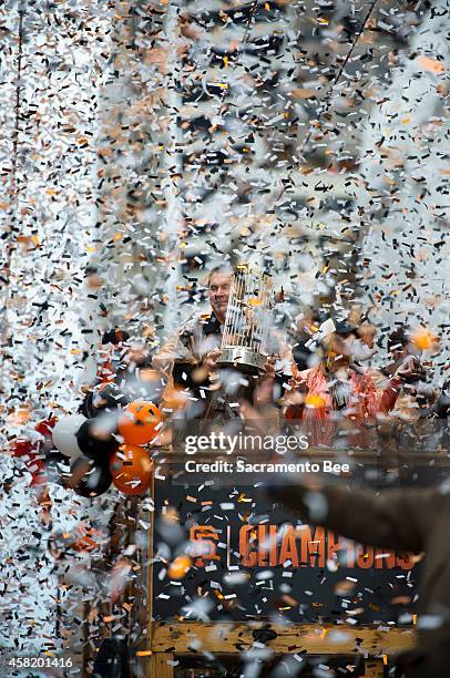 San Francisco Giants manager Bruce Bochy holds the World Series trophy during the team's World Series victory parade through downtown San Francisco...