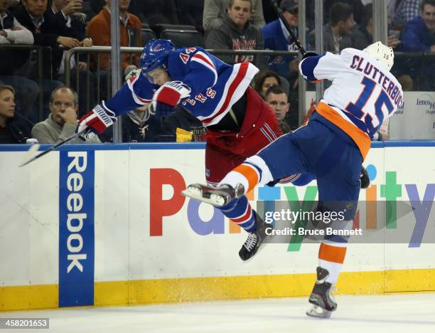 Cal Clutterbuck of the New York Islanders hits Justin Falk of the New York Rangers during the third period at Madison Square Garden on December 20,...