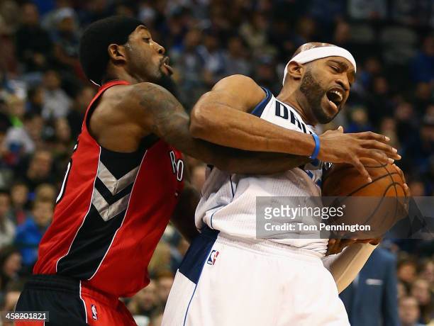 John Salmons of the Toronto Raptors scrambles for the ball against Vince Carter of the Dallas Mavericks at American Airlines Center on December 20,...