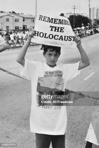 Boy holds a sign reading 'Remember The Holocaust' on Holocaust Remembrance Day in Miami Beach, United States, circa 1994.