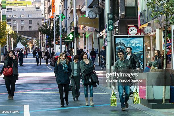 People walk along a shopping street on October 31, 2014 in Andorra la Vella, Andorra. Andorra is a tax haven status although it is in the process of...